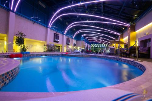 une grande piscine dans un hôtel aux lumières violettes dans l'établissement Casablanca Grand Hotel, à Djeddah