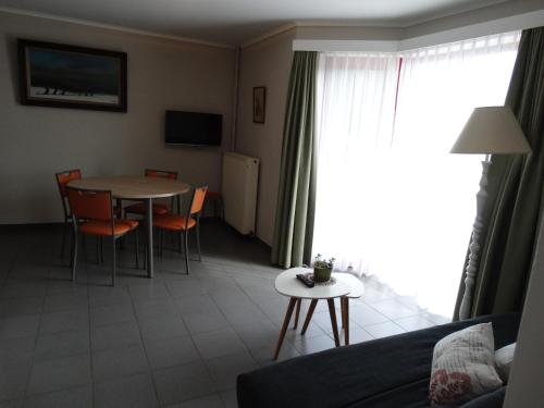 a living room with a table and chairs and a couch at Vakantieverblijf Berg en Dal in Heuvelland