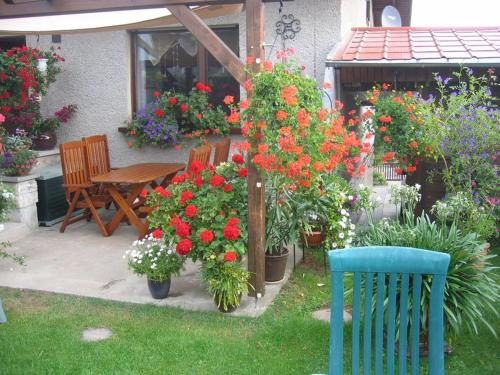 un giardino con tavolo, sedie e fiori di Appartement Studio Kremser a Kranichfeld