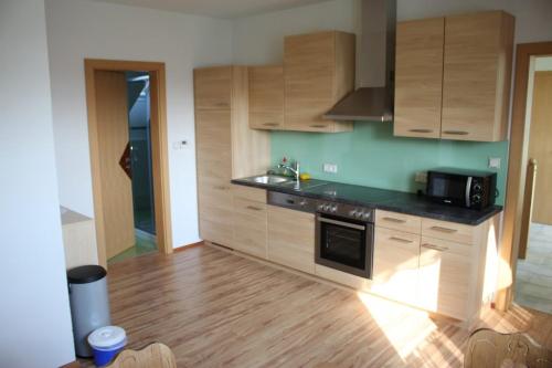 a kitchen with wooden cabinets and a stove top oven at Urlaub am Bauernhof Weichselbaum in Schloss Rosenau