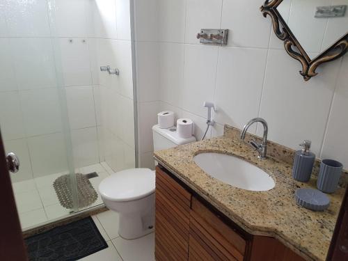 a bathroom with a sink and a toilet and a shower at Porto das Baleias Praia do Forte in Praia do Forte