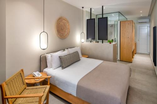 - une chambre avec un lit, une chaise et une table dans l'établissement Callia Retreat Suites - Adults Only, à Fira