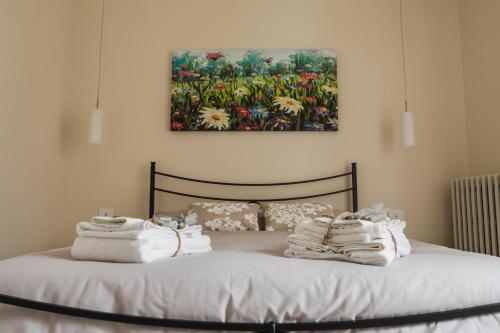 Una cama con toallas y una pintura en la pared. en Agriturismo RiDaRoca, en San Damiano dʼAsti