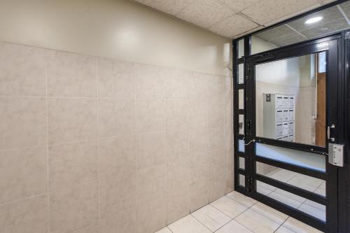 Cette chambre est dotée d'une porte en verre et d'un mur. dans l'établissement Les Princes du Vieux Port - Central & Climatisation - Les Frères de la Loc', à Marseille