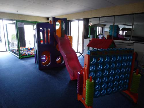 a childrens play room with a slide and a playground at Vakantieverblijf Berg en Dal in Heuvelland