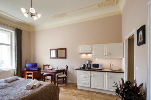 a bedroom with a bed and a kitchen with a table at Old Town - Dusni Apartments in Prague