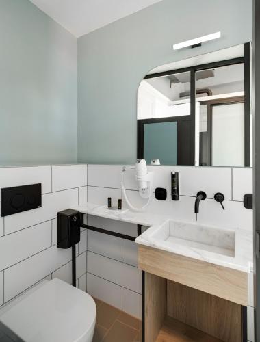 a bathroom with a sink and a toilet and a mirror at Colors Urban Hotel Thessaloniki in Thessaloniki