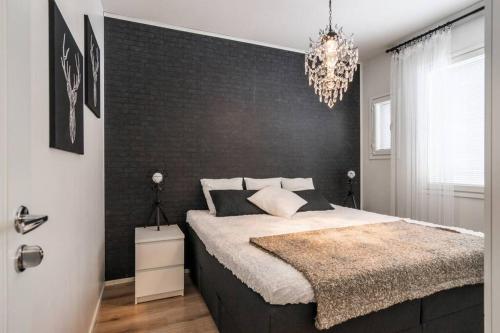 a bedroom with a large bed and a chandelier at Villa Seminaari in Raahe