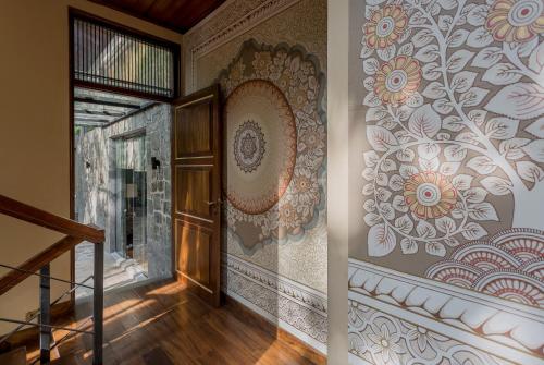 a hallway with a wall with a flower mural at The Far Pavilion by Edwards Collection in Pinnawala