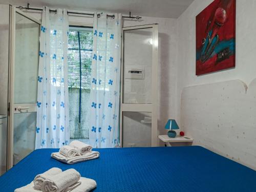 Un dormitorio con una cama azul con toallas. en Casaulente Mare, en Alcamo Marina