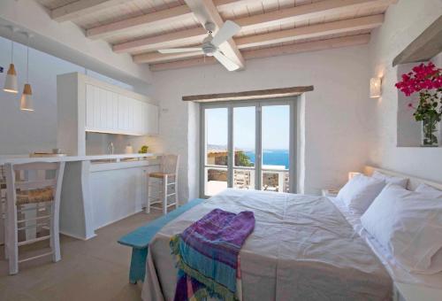 a bedroom with a bed and a kitchen with a view at Cloud Blue in Mýkonos City
