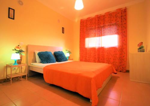 1 dormitorio con 1 cama con cortina roja y ventana en Sunny and Central, en Albufeira