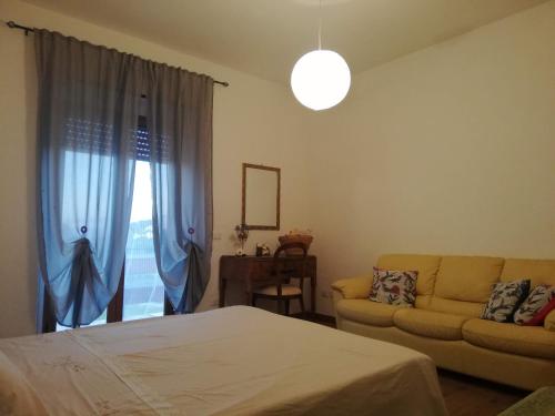 1 dormitorio con cama, sofá y ventana en Antico Casale dei Mercanti, en Montefiascone