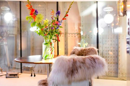 een vaas met bloemen op een tafel in een kamer bij Lightship Amsterdam in Amsterdam