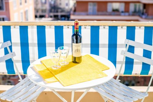 - une bouteille de vin sur une table avec deux verres dans l'établissement VILLA DUBOUCHAGE AP2066 - Nice, by Riviera Holiday Homes, à Nice