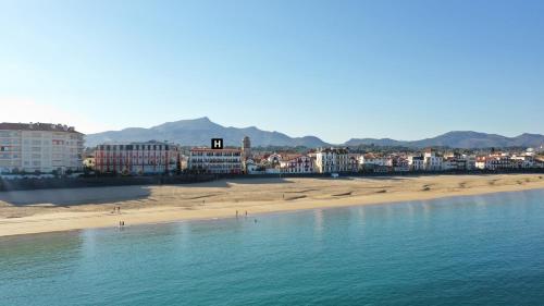 a view of a beach with buildings and a city at Hôtel de la Plage - Saint Jean de Luz in Saint-Jean-de-Luz
