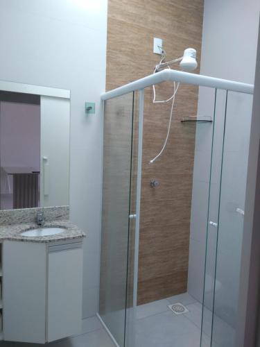 uma casa de banho com um chuveiro e um lavatório. em Casa da Canastra em Delfinópolis