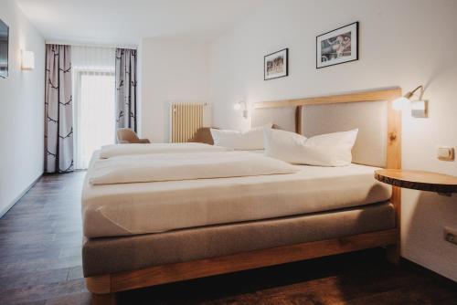 a hotel room with a large bed and a table at Seehotel zur Post in Tegernsee