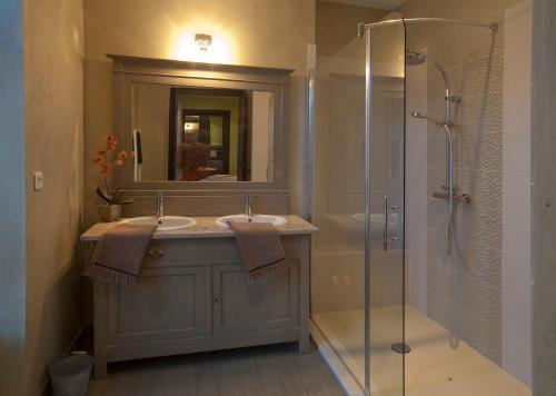 a bathroom with two sinks and a glass shower at Bed & Breakfast Demeure du Pareur in Villeneuve-Minervois