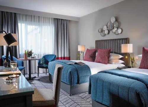 a hotel room with two beds and a table at Fairways Hotel Dundalk in Dundalk