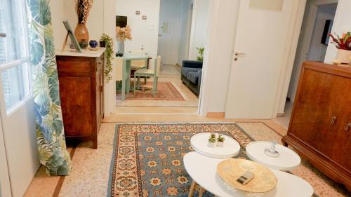 un soggiorno con 2 tavoli bianchi in una stanza di Comfortable Apartment in Kallithea by Athenian Homes ad Atene