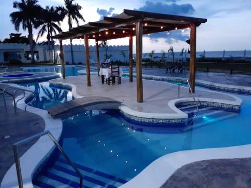 a pool with a gazebo and a table and chairs at Hotel Castillo del Mar in Ríohacha