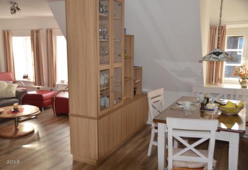 eine Küche und ein Esszimmer mit einem großen Holzschrank in der Unterkunft Ohl Dörp 10, Wrixum auf der Insel Föhr in Wrixum