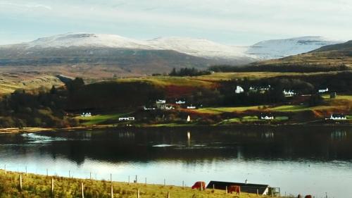 a view of a lake with snow covered mountains at Harbor View in Uig