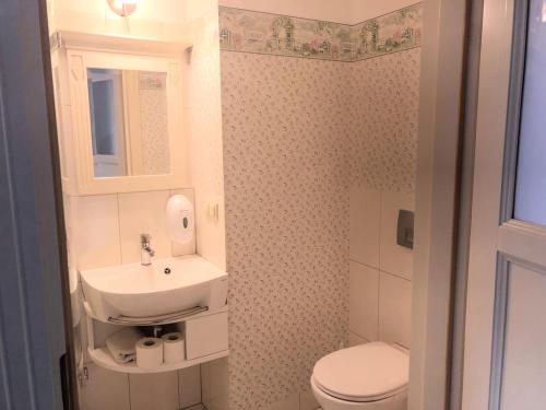 a small bathroom with a sink and a toilet at Ośrodek Ukazia in Orzechowo