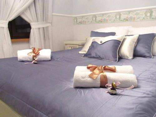a blue bed with towels and bows on it at Ośrodek Ukazia in Orzechowo