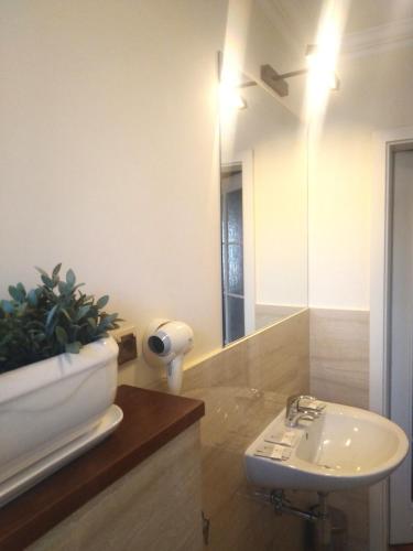 a bathroom with a sink and a mirror and a plant at American House Hennela in Warsaw