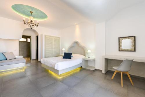 um quarto branco com uma cama e uma cadeira em Blue Suites em Fira