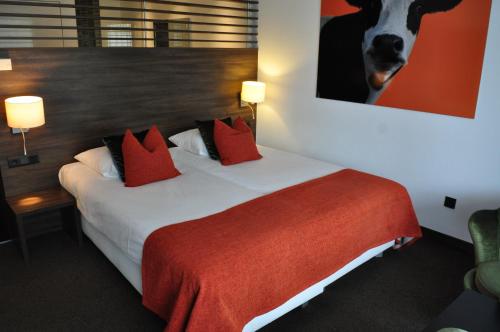 a hotel room with a bed with red pillows at Van der Valk Hotel Nuland - 's-Hertogenbosch in Nuland
