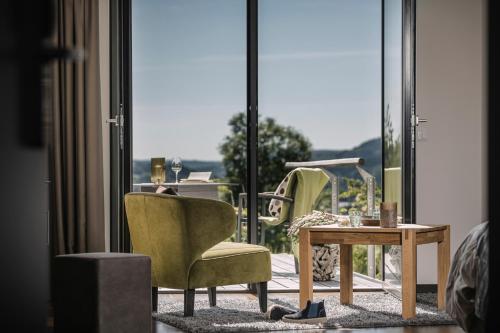 a room with a chair and a table and a window at Boutiquehotel Genusswerk Eifel in Körperich