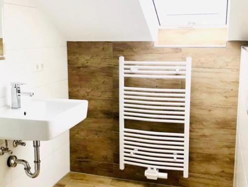 a bathroom with a white towel rack next to a sink at Gästezimmer am Hochrhein in Lauchringen