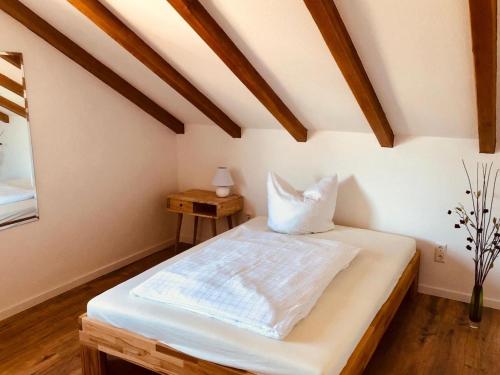 a bedroom with a bed and a table with a lamp at Gästezimmer am Hochrhein in Lauchringen