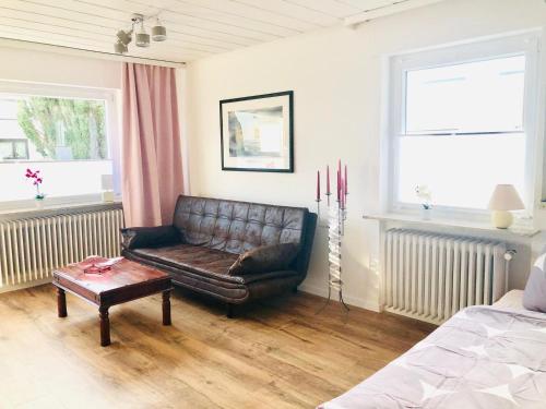 a living room with a leather couch and a table at Gästezimmer am Hochrhein in Lauchringen