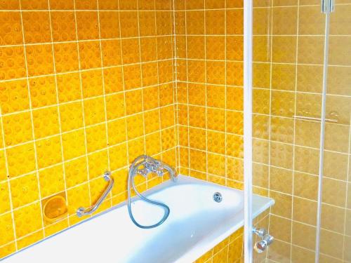 a bathroom with orange tiled walls and a bath tub at Gästezimmer am Hochrhein in Lauchringen