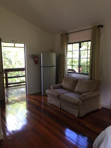 ein Wohnzimmer mit einem Sofa und einem Kühlschrank in der Unterkunft Santa Cruz Cabins in Santa Elena