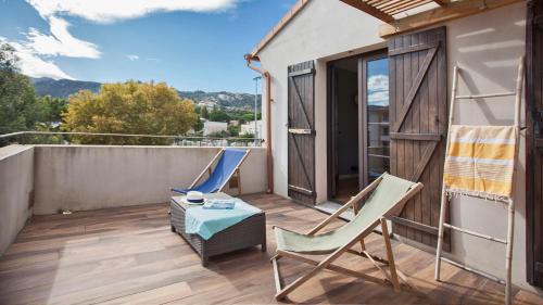 a patio with two chairs and a table on a balcony at Laniella location in Calvi