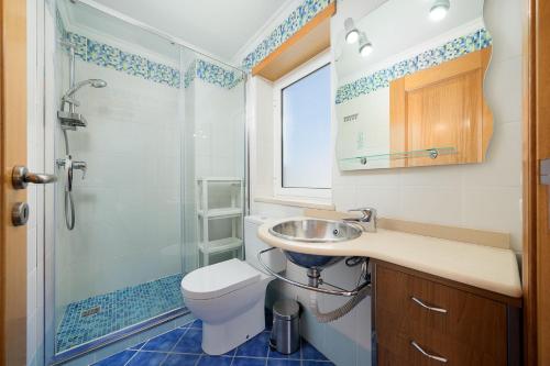 a bathroom with a toilet and a sink and a shower at Porto de Mos 95 by Destination Algarve in Porto de Mós