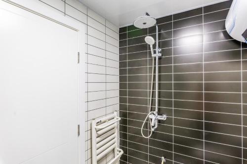y baño con ducha y azulejos negros. en Qingdao Huangdao·Qingdao Silver Beach·, en Qingdao