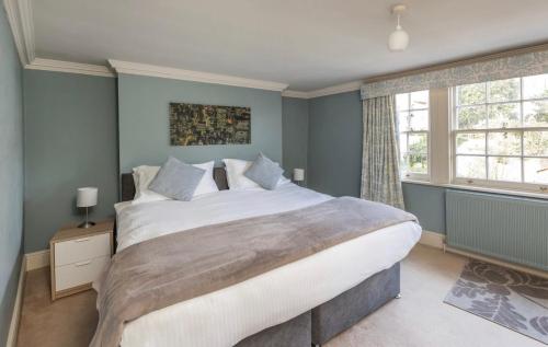 1 dormitorio con 1 cama grande y paredes azules en Ivory House - Stunning Central Townhouse, en Bath