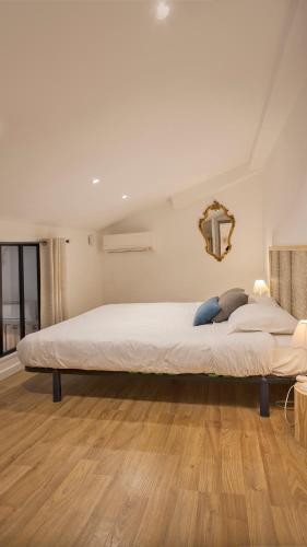 a large white bed in a room with wooden floors at Laniella location in Calvi