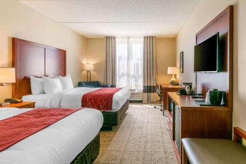 a hotel room with two beds and a flat screen tv at Comfort Inn & Suites Nashville Franklin Cool Springs in Franklin