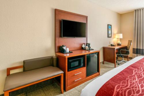a hotel room with a television and a bed and a chair at Comfort Inn & Suites Nashville Franklin Cool Springs in Franklin