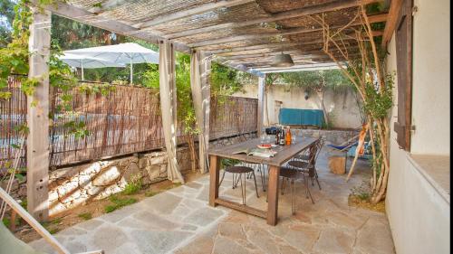a patio with a wooden table and chairs at Laniella location in Calvi