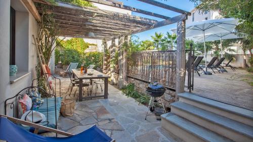 a patio with a table and chairs and an umbrella at Laniella location in Calvi