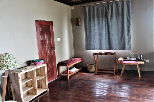 a room with wooden floors and a door and a table at Wag Hill Lodge & Spa in Mwanza