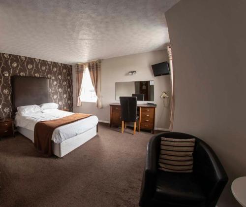 伍德哈姆斐爾斯的住宿－奧克蘭酒店，一间卧室配有一张床、一张桌子和一把椅子